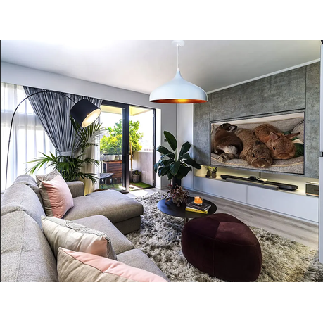 Modern living room with a gray sofa, coffee table, and television displaying puppies.