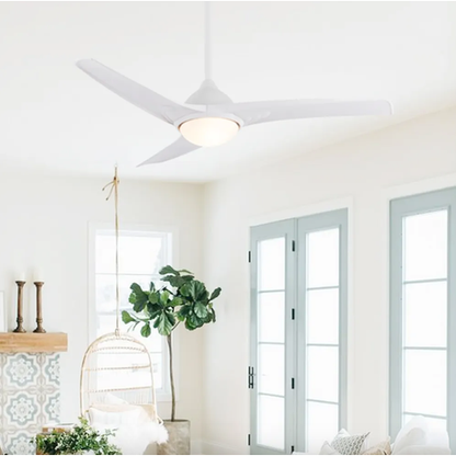 Ceiling fan in a bright room with large windows and decorative elements.