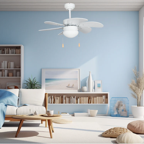 Modern living room with a ceiling fan, bookshelf, and decorative items against a light blue wall.