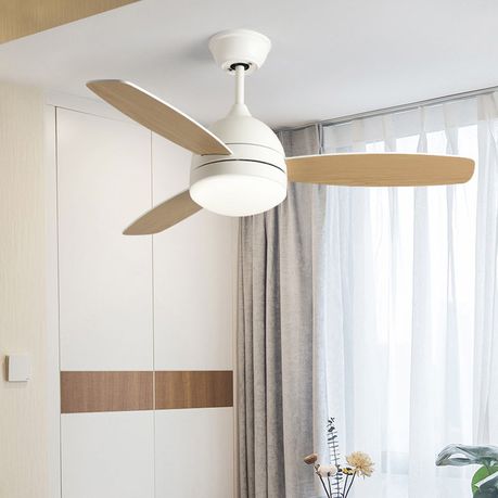 Ceiling fan with wooden blades in a room with curtains and a plant.