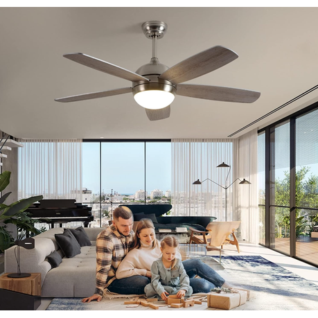 Family sitting on a couch in a modern living room with a ceiling fan.