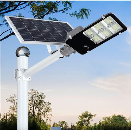 Solar street light with a solar panel and LED lights on a pole against a blue sky.