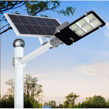 Solar street light with a solar panel and LED lights on a pole against a blue sky.